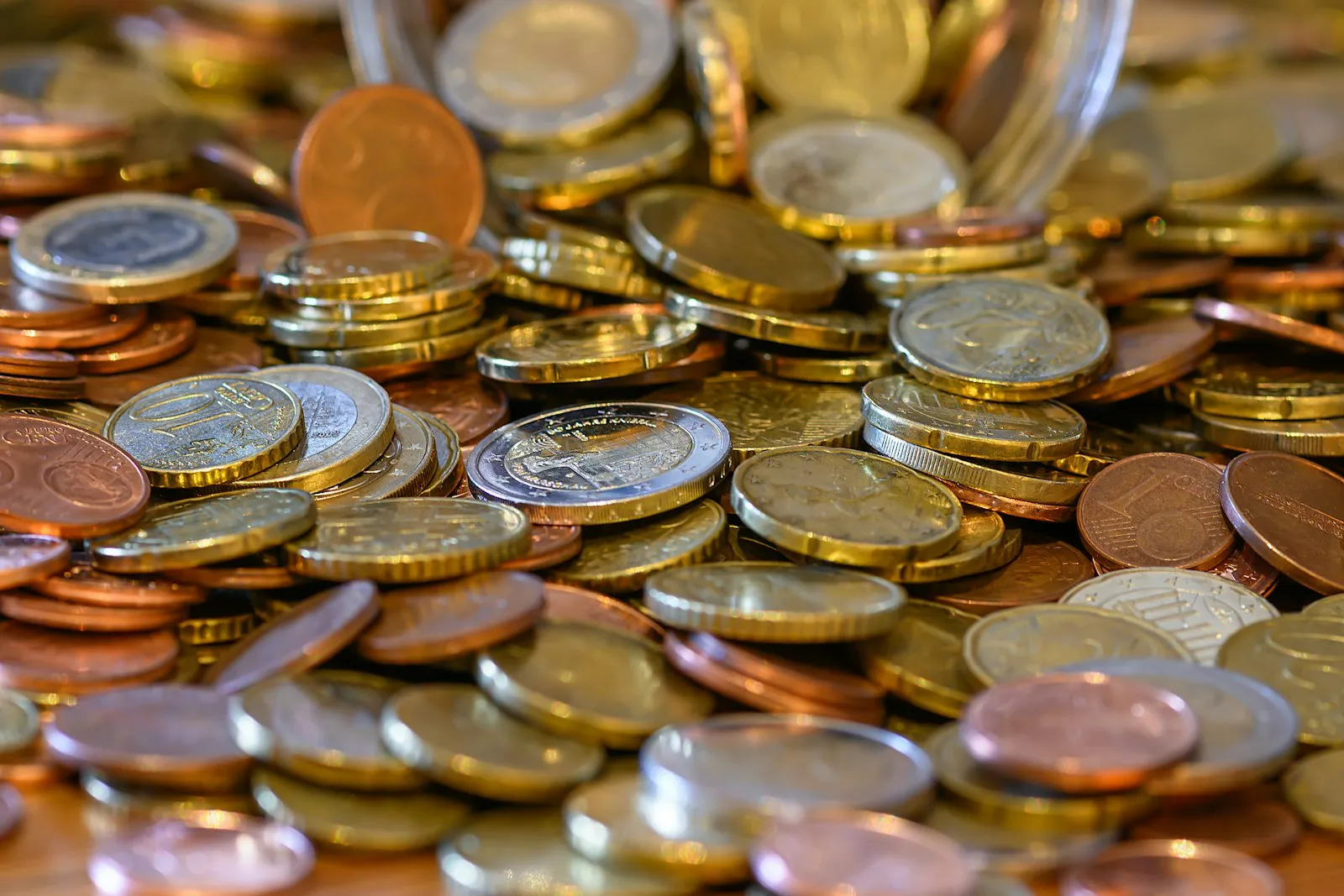 Montón de monedas de euro sobre una mesa de madera