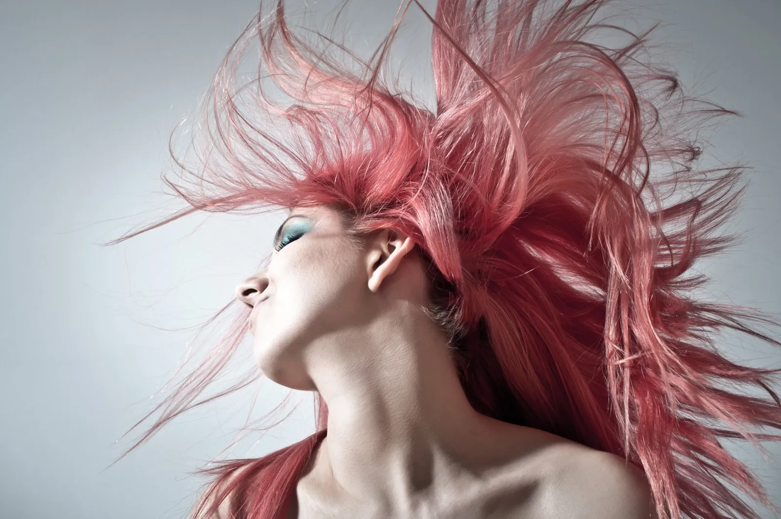 Mujer con el pelo teñido de rosa en movimiento