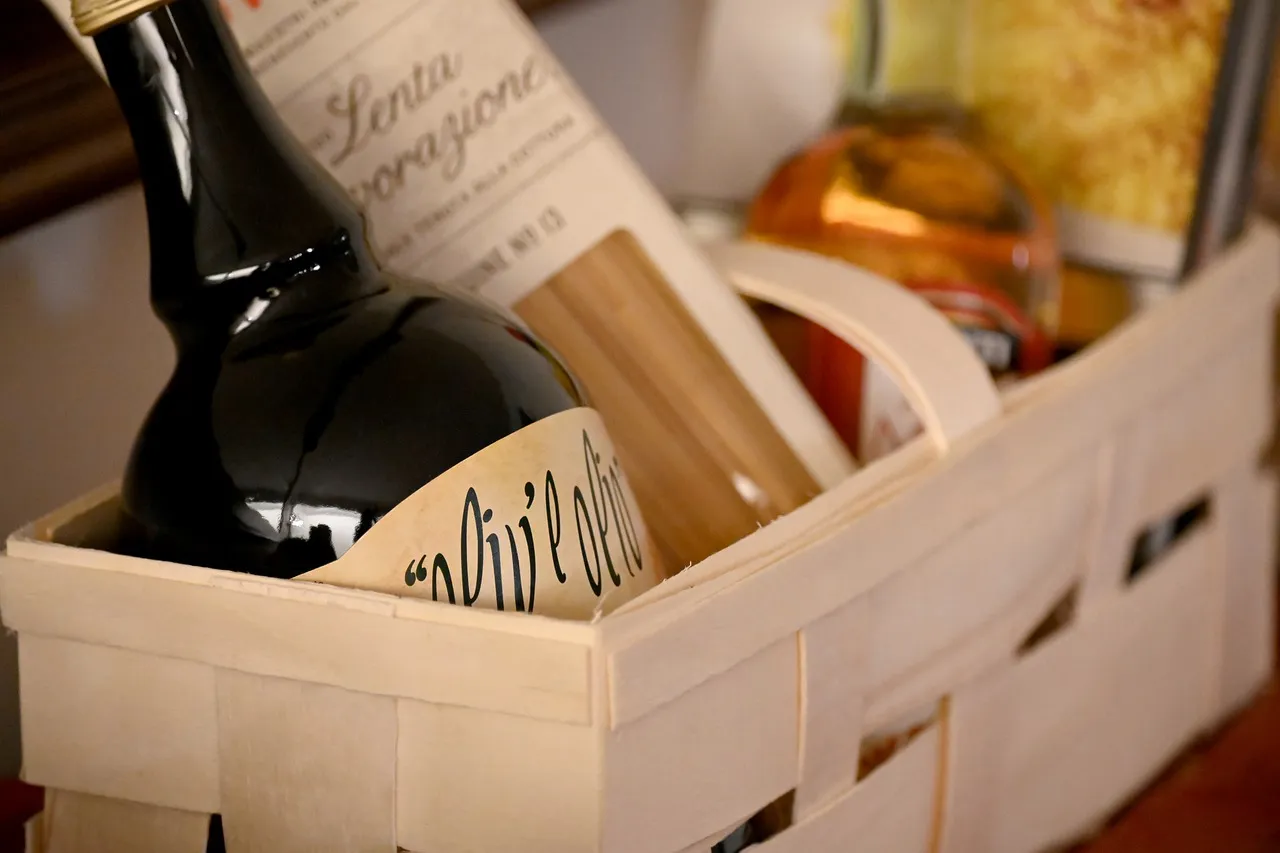 Cesta de regalo con botella de vino y productos gourmet