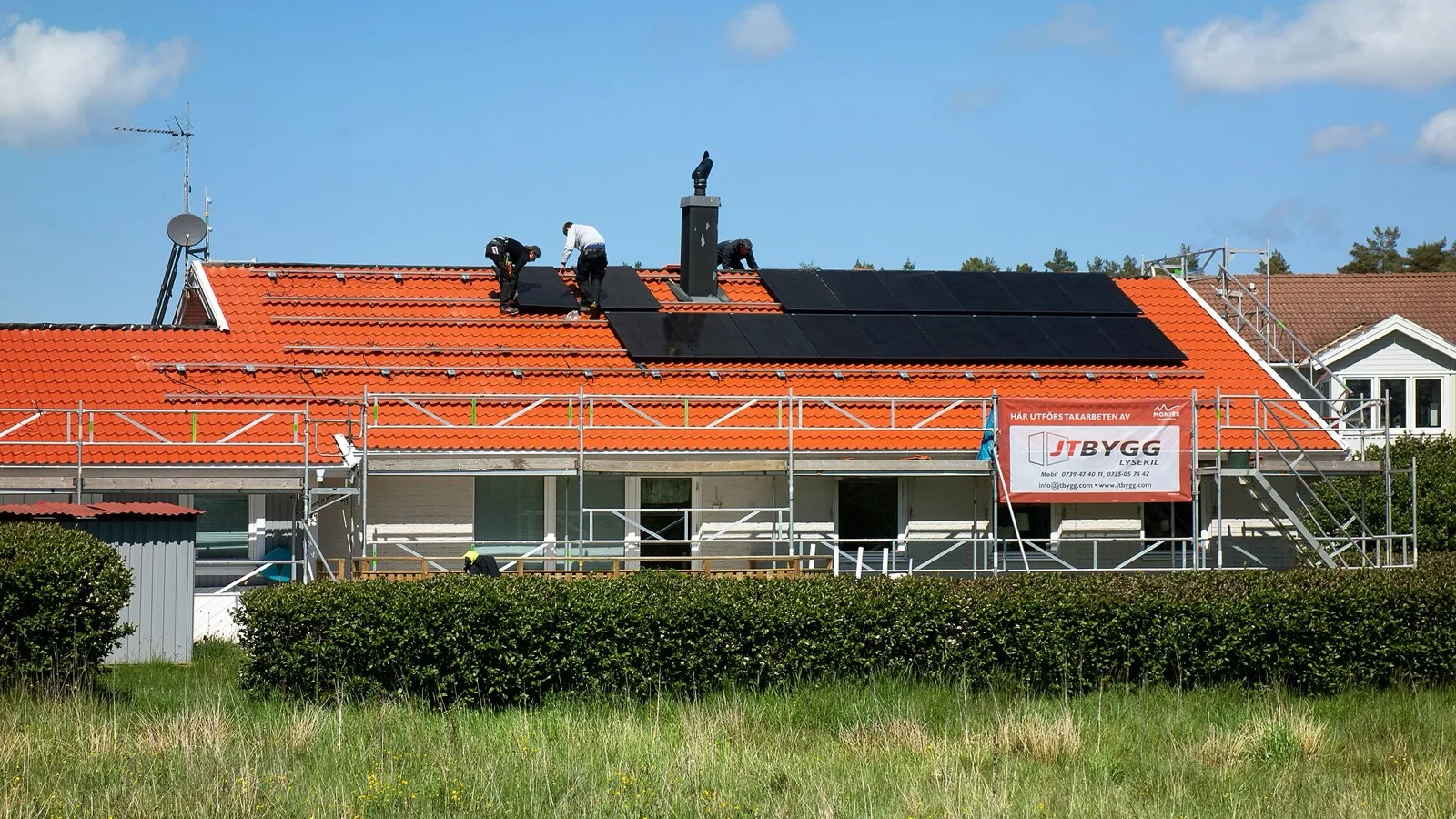 Instaladores colocando placas solares en el tejado de una vivienda