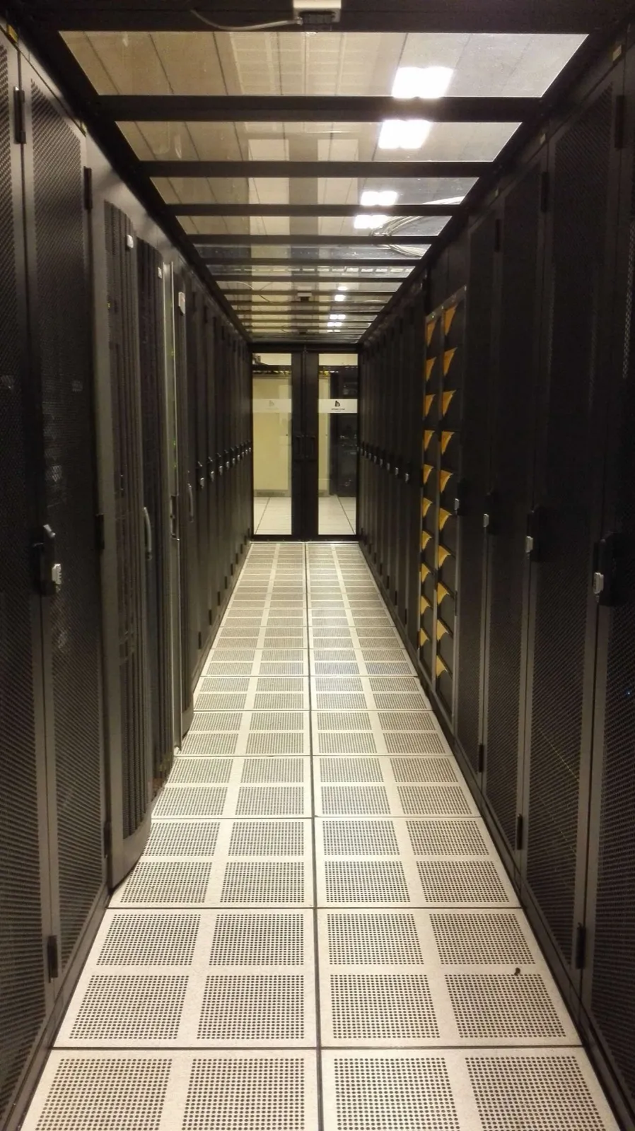 Pasillo de un centro de datos entre filas de racks cerrados