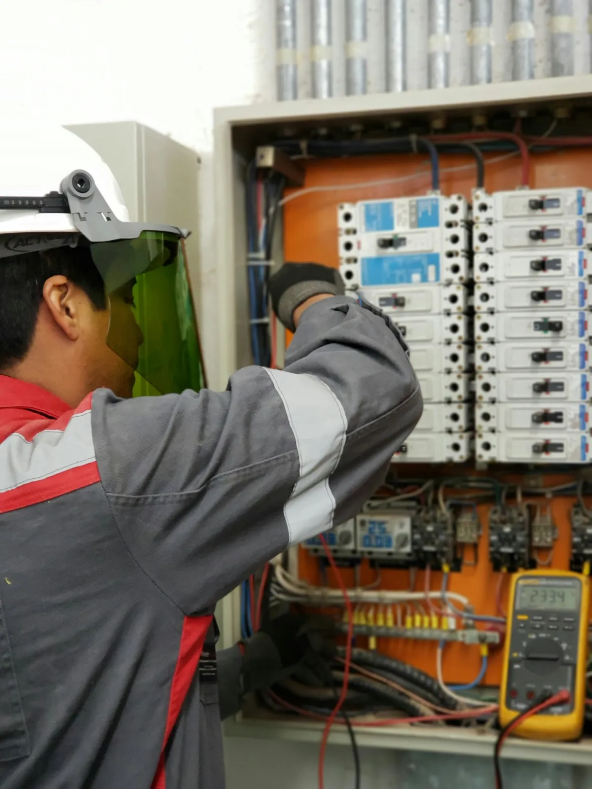 Técnico con casco comprobando un cuadro eléctrico